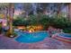 Backyard swimming pool and hot tub with tropical landscaping, decorative statues, and ambient lighting at 1 Via Mira Monte, Henderson, NV 89011