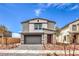 Charming two-story home boasts a modern exterior, landscaped yard, and a welcoming red door at 1011 Gentle Swan St # Lot 697, Henderson, NV 89011