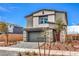 A modern two-story home with stone accents, a gray garage door, and desert landscaping at 1011 Gentle Swan St # Lot 697, Henderson, NV 89011