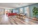 Open-concept living area featuring wood-look floors, a dining set, and comfortable seating at 1011 Gentle Swan St # Lot 697, Henderson, NV 89011