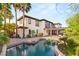 Stunning backyard with a pool, covered patio, and lush landscaping, creating a perfect oasis for relaxation and entertainment at 10301 Orkiney Dr, Las Vegas, NV 89144