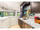 Elegant home bar with marble countertops, wine fridge, glassware storage, and outside view at 10301 Orkiney Dr, Las Vegas, NV 89144