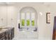 Bright bathroom features an arched alcove with a soaking tub and beautiful finishes at 10301 Orkiney Dr, Las Vegas, NV 89144