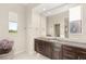 A bathroom featuring a large mirror, vanity, and a window offering natural light at 10301 Orkiney Dr, Las Vegas, NV 89144