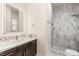 Modern bathroom featuring a tiled shower, marble countertop, and illuminated mirror at 10301 Orkiney Dr, Las Vegas, NV 89144