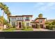 Stunning two-story home showcasing lush landscaping and an attached garage, creating a welcoming curb appeal at 10301 Orkiney Dr, Las Vegas, NV 89144