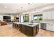 A modern open-concept kitchen seamlessly integrates with the living area, boasting a large island with seating and stylish pendant lighting at 10301 Orkiney Dr, Las Vegas, NV 89144