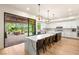 A spacious kitchen features a large island with seating, sleek white cabinetry, and a seamless transition to the outdoor patio at 10301 Orkiney Dr, Las Vegas, NV 89144