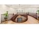 Elegant landing with wood floors, curved railings, and decorative chandelier at 10301 Orkiney Dr, Las Vegas, NV 89144