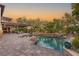 An open backyard patio with a pool, waterfall, and beautiful desert landscaping at 10301 Orkiney Dr, Las Vegas, NV 89144