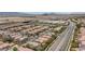 An aerial view of a residential neighborhood with many similar homes, tree-lined streets and nearby mountains at 11221 Victoria Medici St, Las Vegas, NV 89141