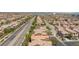 An aerial view of a residential neighborhood showcasing well-maintained homes with mature trees and nearby mountains at 11221 Victoria Medici St, Las Vegas, NV 89141