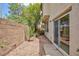 A zero-maintenance backyard featuring a brick wall, decorative rock and shrubbery with a small concrete patio at 11221 Victoria Medici St, Las Vegas, NV 89141