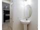 Bright bathroom with a pedestal sink and round mirror, adjoining the kitchen through an open doorway at 11221 Victoria Medici St, Las Vegas, NV 89141