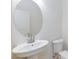 White pedestal sink features a round mirror, paired with a toilet in a bright bathroom at 11221 Victoria Medici St, Las Vegas, NV 89141