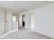 Hallway featuring white carpet, neutral walls, and white banister, with doorways leading to various rooms at 11221 Victoria Medici St, Las Vegas, NV 89141