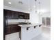 Open kitchen featuring granite countertops, dark wood cabinets, and a center island at 11221 Victoria Medici St, Las Vegas, NV 89141
