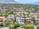 Expansive aerial view of a luxury home with a pool in a lush green golf community with mountain views at 11503 Glowing Sunset Ln, Las Vegas, NV 89135