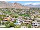 Expansive aerial view of a luxury home with a pool in a lush green golf community with mountain views at 11503 Glowing Sunset Ln, Las Vegas, NV 89135
