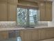 Bright kitchen featuring custom cabinetry, tiled backsplash, stainless steel dishwasher, and a garden view window at 11503 Glowing Sunset Ln, Las Vegas, NV 89135