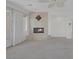 Living room featuring a stone fireplace, neutral carpeting, and glass doors to the balcony at 11503 Glowing Sunset Ln, Las Vegas, NV 89135