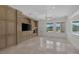 Living room featuring custom built-ins, tile floors, and scenic backyard views at 11503 Glowing Sunset Ln, Las Vegas, NV 89135