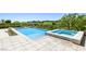 Beautiful backyard pool and spa with surrounding patio and lush greenery, perfect for outdoor entertaining at 11503 Glowing Sunset Ln, Las Vegas, NV 89135