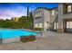 Backyard pool with a wooden fire pit, desert landscaping, and a view of the home's architecture at 11503 Glowing Sunset Ln, Las Vegas, NV 89135