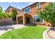 Relaxing backyard featuring a covered patio, turf lawn, mature landscaping and brick perimeter at 11847 Corenzio Ave, Las Vegas, NV 89138