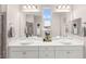 Bright bathroom featuring a double sink vanity, modern fixtures, and a window with scenic views at 11847 Corenzio Ave, Las Vegas, NV 89138