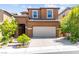 Attractive two-story home featuring a tiled roof, arched entry, two-car garage, and lush landscaping at 11847 Corenzio Ave, Las Vegas, NV 89138