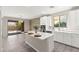 Open-concept kitchen with a large island, white cabinets, and access to the backyard at 11847 Corenzio Ave, Las Vegas, NV 89138