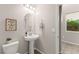 Powder room with pedestal sink, decorative mirror, and modern lighting at 11847 Corenzio Ave, Las Vegas, NV 89138