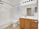 Bathroom featuring a vanity with a sink, toilet, a shower-tub and a window at 1212 E Rome Blvd, North Las Vegas, NV 89086