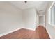Spacious bedroom with wood-look flooring, a window, and a glimpse into an adjacent room at 1212 E Rome Blvd, North Las Vegas, NV 89086