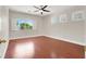 Large bedroom with wood-look floors, a ceiling fan, and three windows with bright light at 1212 E Rome Blvd, North Las Vegas, NV 89086