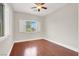 Light-filled bedroom with wood-look floors, a ceiling fan, and a window with white shutters at 1212 E Rome Blvd, North Las Vegas, NV 89086