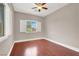 Bedroom featuring hardwood floors, window with shutters and ceiling fan at 1212 E Rome Blvd, North Las Vegas, NV 89086