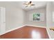 Bedroom with wood floors, ceiling fan, and window with white shutters providing natural light at 1212 E Rome Blvd, North Las Vegas, NV 89086