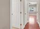 Hallway leading to bedroom with doors and hardwood floors at 1212 E Rome Blvd, North Las Vegas, NV 89086