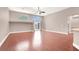 Bright living room with hardwood floors, large windows, and a ceiling fan at 1212 E Rome Blvd, North Las Vegas, NV 89086