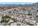 Dynamic aerial view of a residential neighborhood highlighting manicured lawns, swimming pools, and convenient highway access at 130 Park Ridge Ln, Henderson, NV 89002