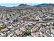 High-angle aerial view of a well-maintained community featuring diverse home styles, winding roads, and verdant landscapes at 130 Park Ridge Ln, Henderson, NV 89002