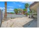 Backyard featuring a covered patio, desert landscaping, and mature palm trees at 130 Park Ridge Ln, Henderson, NV 89002