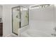 Well-lit bathroom featuring a glass-enclosed shower and a separate bathtub with white tile surround at 130 Park Ridge Ln, Henderson, NV 89002