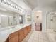 Spacious bathroom featuring double sinks, long vanity, tile flooring, and glass-enclosed shower at 130 Park Ridge Ln, Henderson, NV 89002