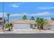 Well-maintained single-story home with desert landscaping, a spacious driveway, and mature palm trees at 130 Park Ridge Ln, Henderson, NV 89002