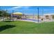Colorful playground area with swings and climbing structures, set against a green lawn at 130 Park Ridge Ln, Henderson, NV 89002