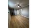 This bedroom offers wood floors, neutral paint, a ceiling fan, and white baseboards at 150 Greenbriar Townhouse Way, Las Vegas, NV 89121