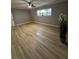 Spacious bedroom with wood-look flooring, neutral walls, ceiling fan, and a large window at 150 Greenbriar Townhouse Way, Las Vegas, NV 89121